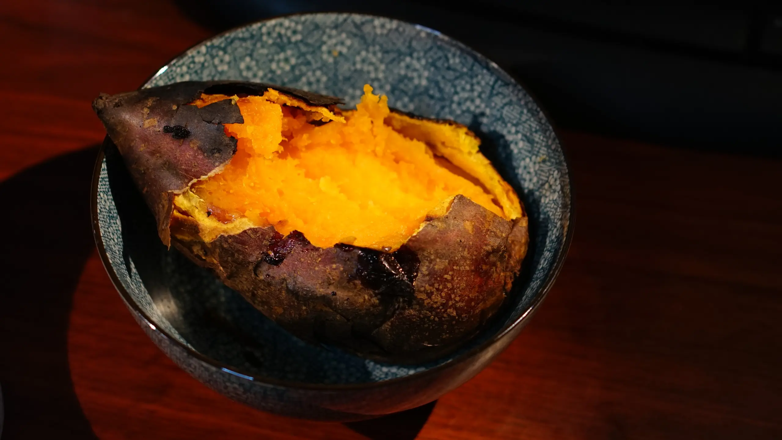 一條剝開的烤地瓜,露出橘黃色的果肉